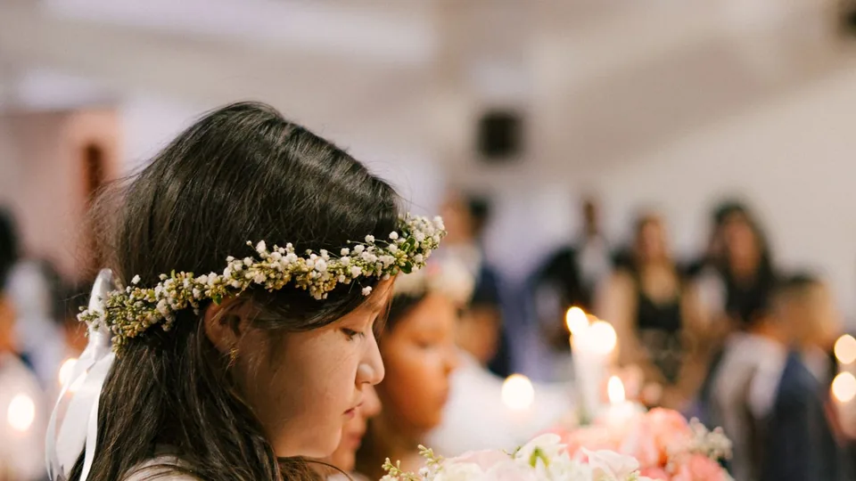 Una niña con corona de flores durante la celebración de su primera comunión