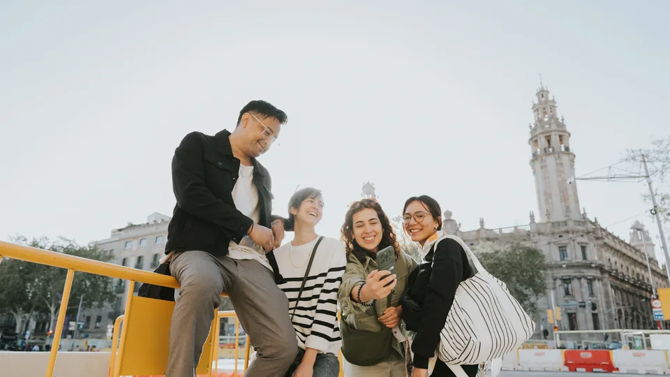 Un grupo de amigos se hace un selfi junto a un edificio histórico de Barcelona