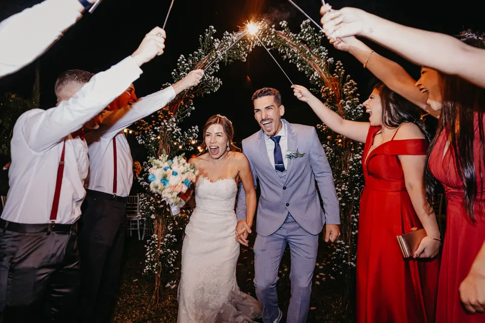 Los novios salen entre dos filas de invitados que levantan bengalas