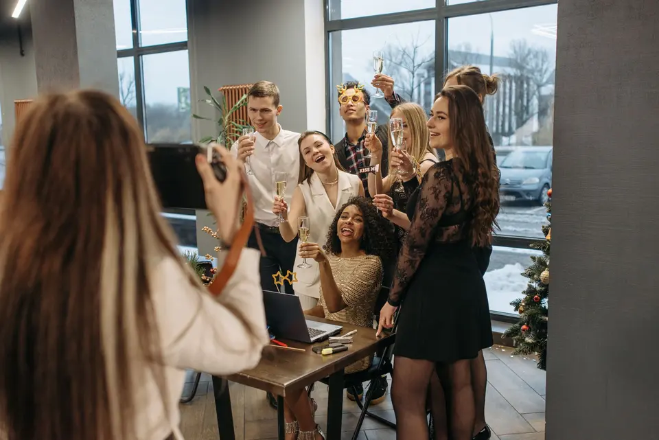 Una compañera hace una foto con el móvil a un grupo de colegas que brindan en la oficina durante la fiesta