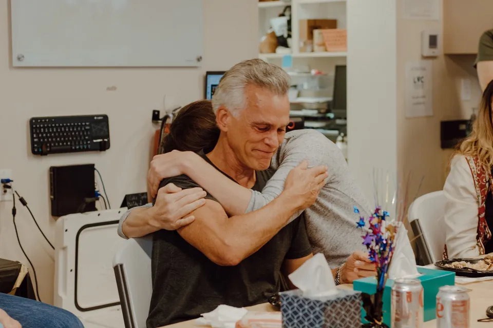 Una compañera abraza al homenajeado durante su comida de jubilación