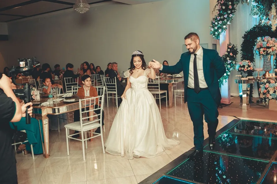 La quinceañera entra al salón de la mano de su padre ante los invitados