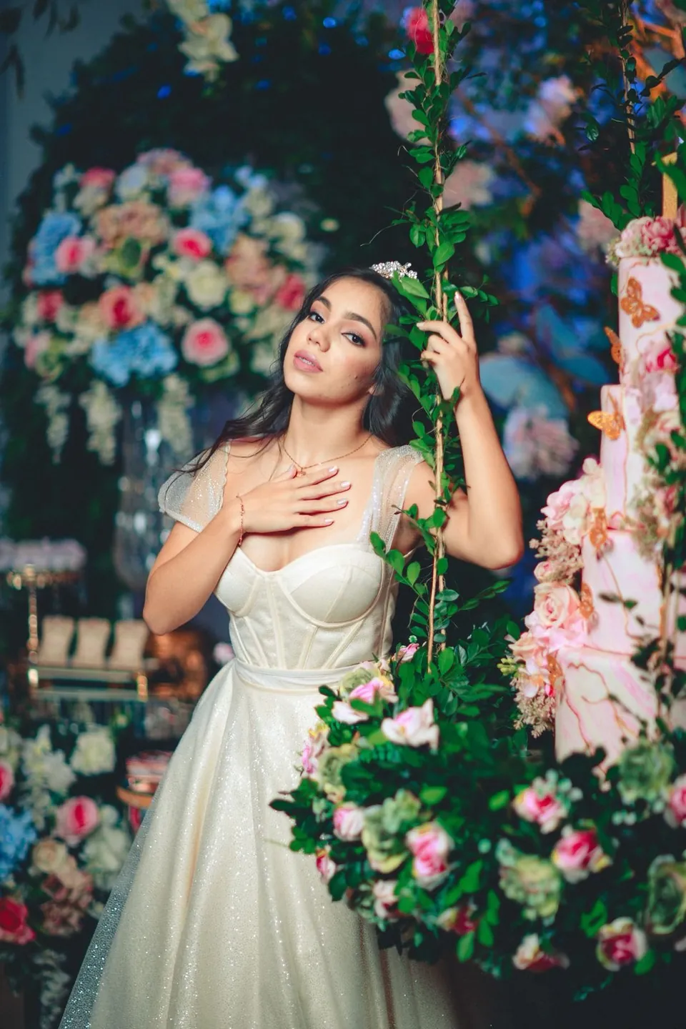 La quinceañera junto a un columpio cubierto de flores