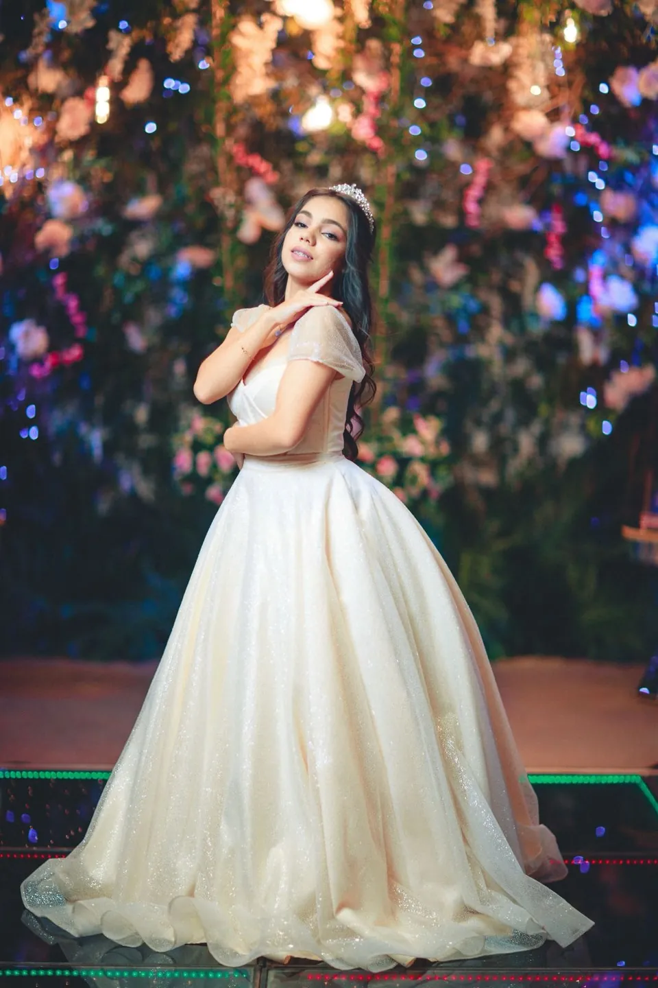 Retrato de la quinceañera de pie, con la mano cerca del rostro